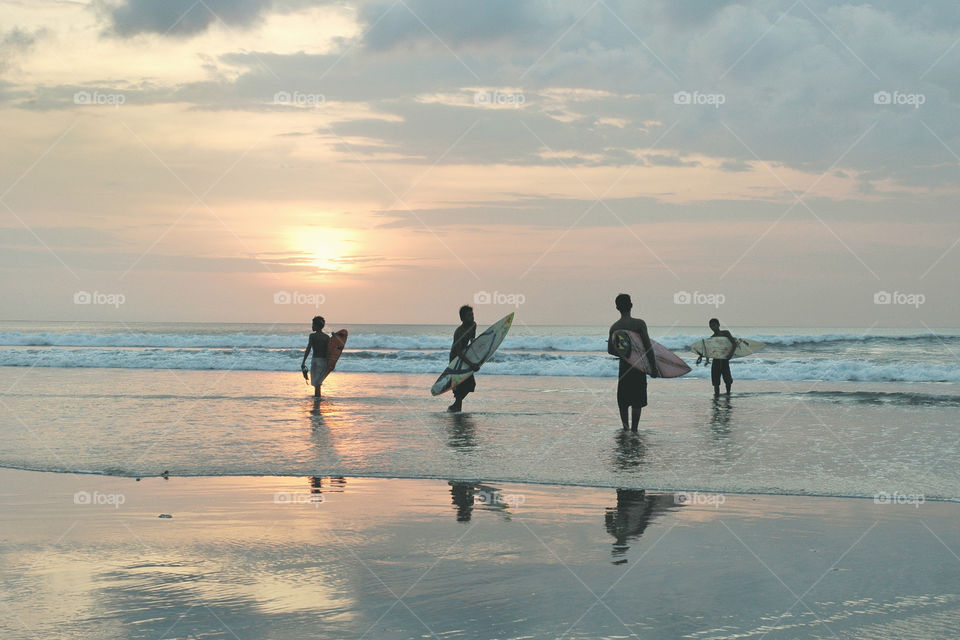 the sunset and surfers