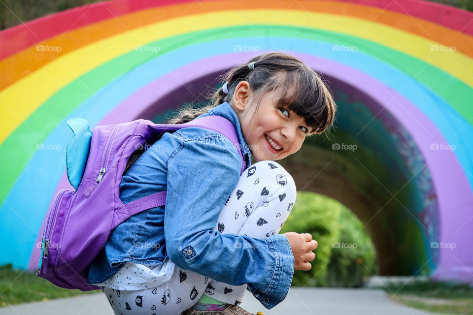 Cute little girl with a rainbow background