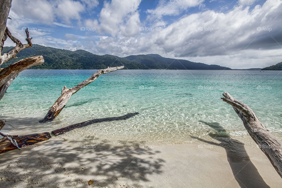 Scenic view of beach against cloudy sky