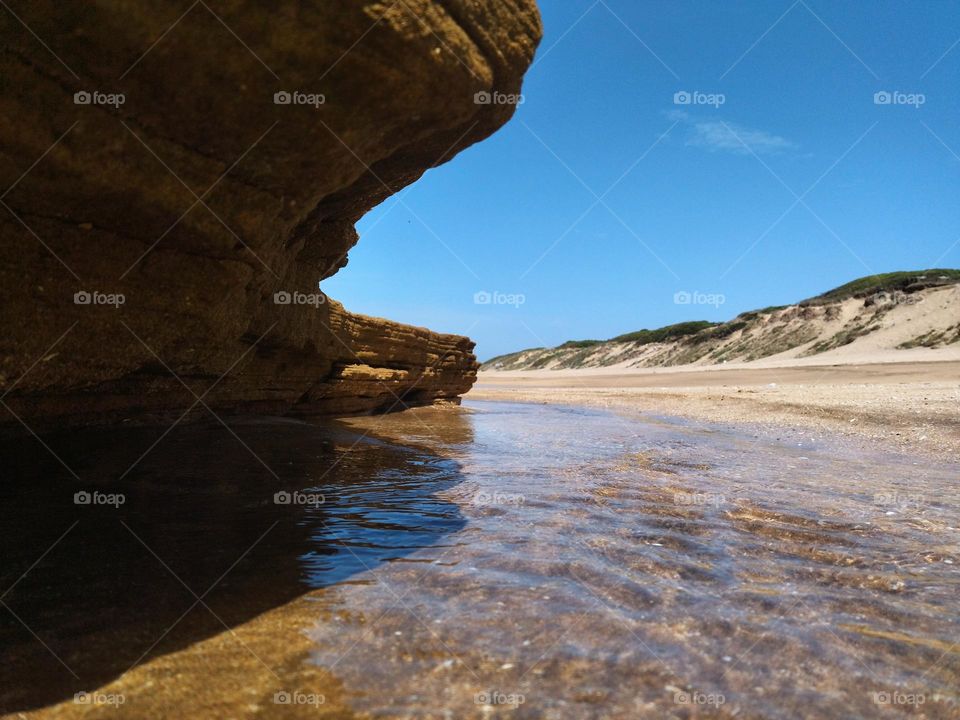 In the shadow of rock from beach