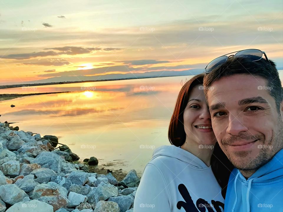 A couple, a lake and the sunset