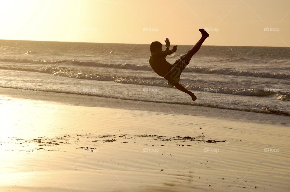 Capoeira man at sunset in the beach 