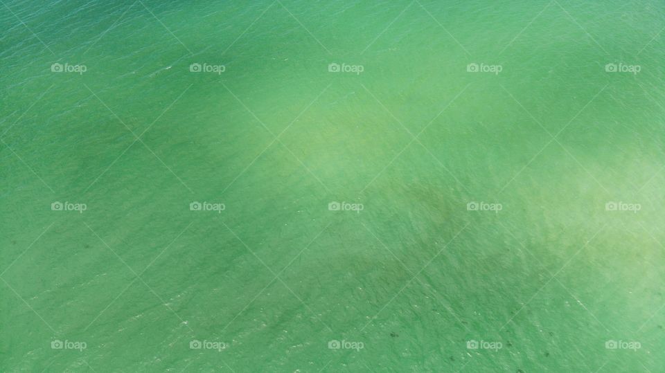 clear water in the ocean. A blue, green, sea surface for background. View From above, flat lay. Aerial view, tropical beach, top view of the waves on the beautiful sand beach. texture of water