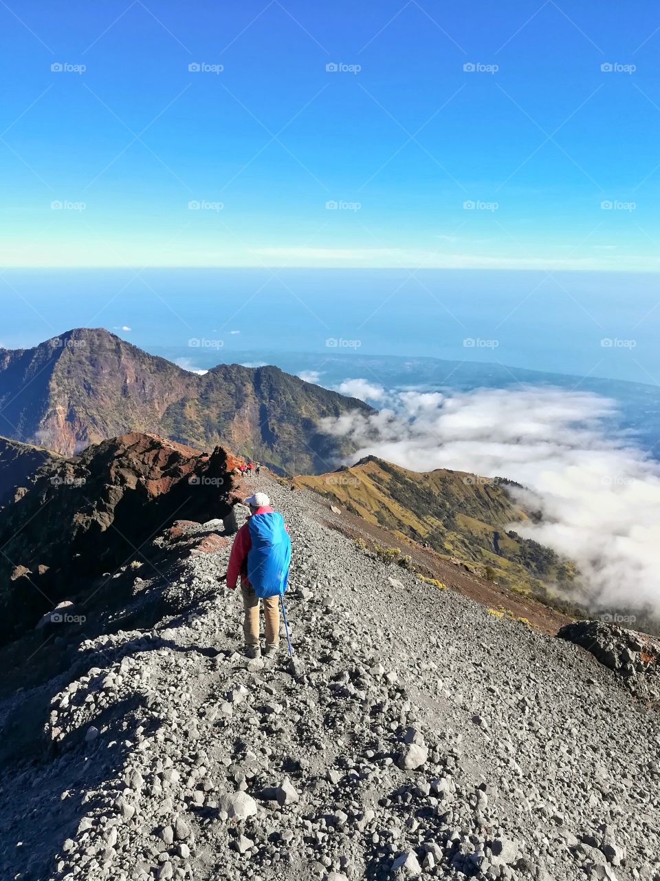 Backpacker is walking to the top of mountain.