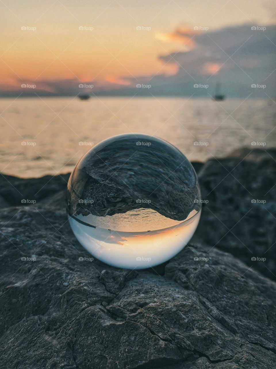 Top view of lensball,  crystal ball at the Adriatic seaside against sunset sky close up