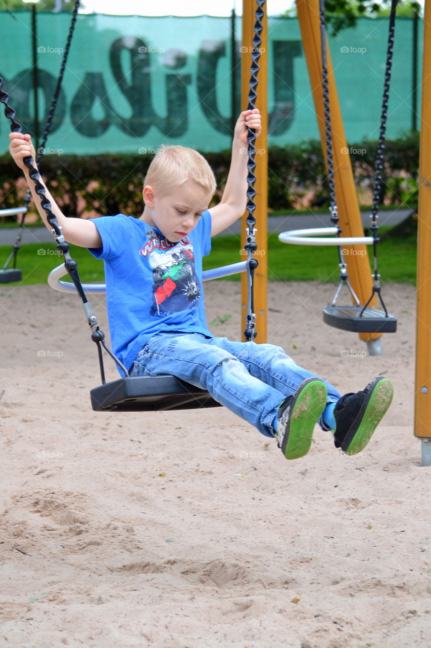 Boy swinging at the playground