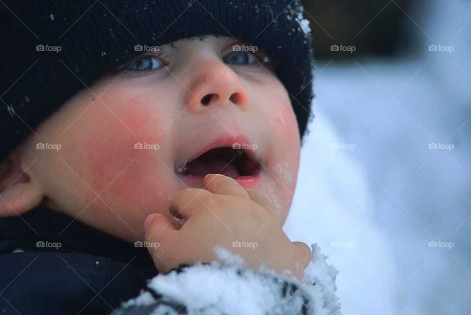 Cute toddler eating snow