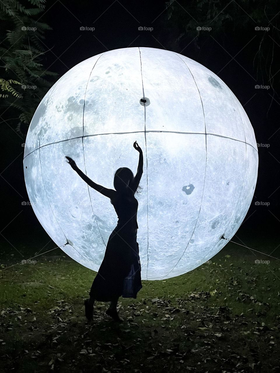 Woman Dancing in Front of the Art Installation Moon