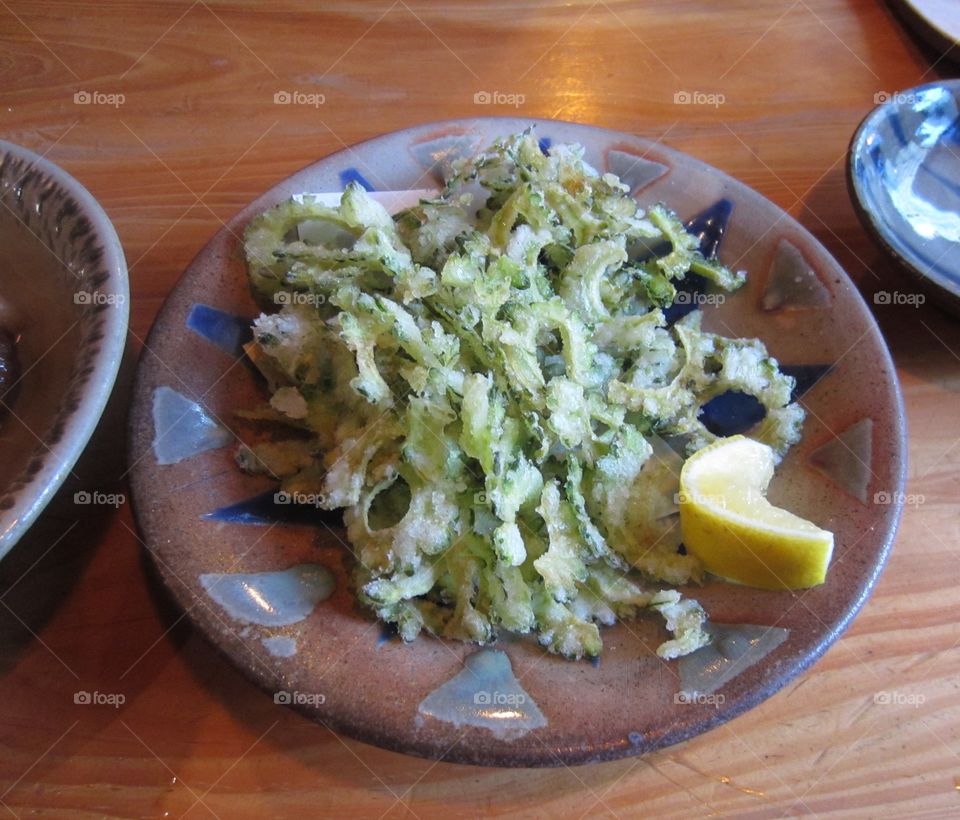 Appetizer of Goya, Okinawan Bitter Melon.  Fried and crispy, with fresh lemon squeezed over it. Traditional Pub Snackmin Okinawa. Japan