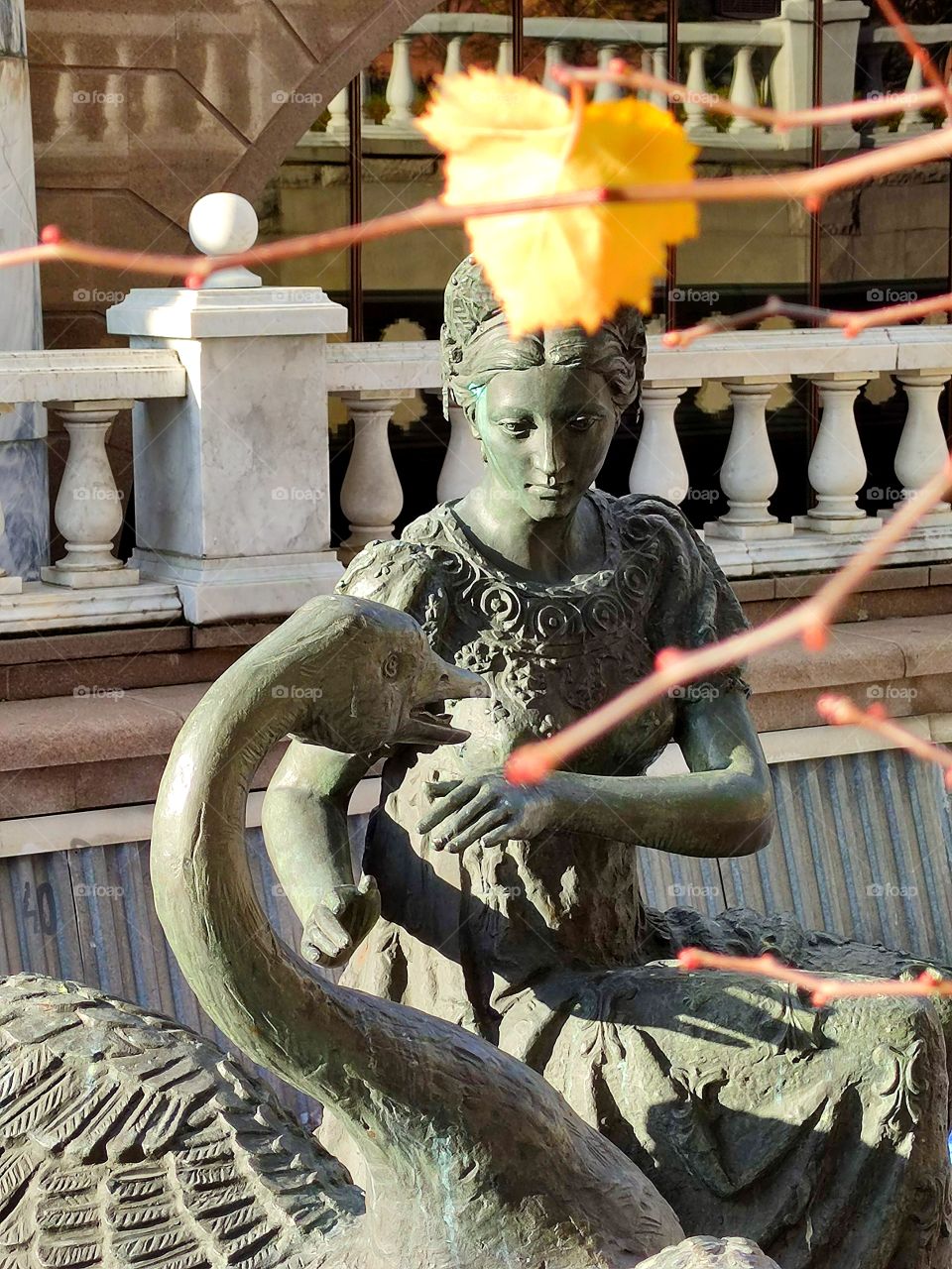 Moscow. Autumn. Alexander Garden. Fountain figures based on Russian fairy tales. The princess and the swan. In the foreground there is a yellow birch leaf