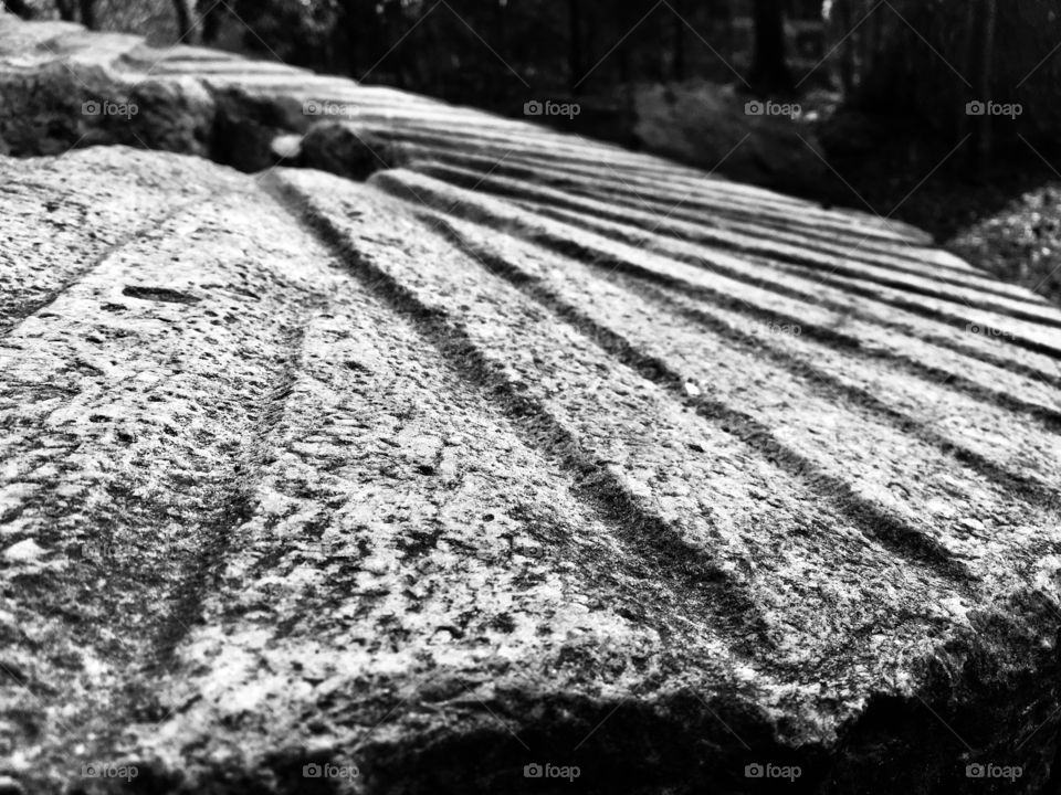 Black and white image of a large grinding stone from an old gristmill. Used for crushing corn and wheat. 