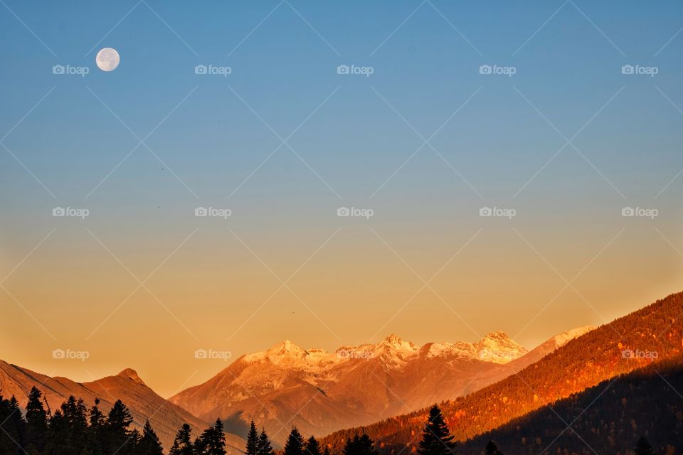 Moon in morning twilight over beautiful mountain scape at Georgia countryside 