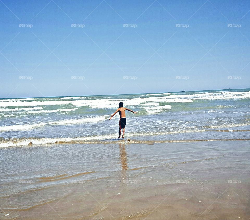 A boy making fun on shore