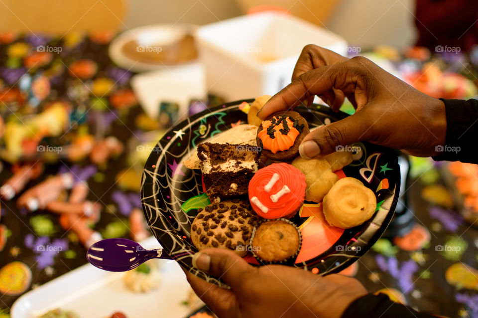 Woman holding Fresh baked halloween cookies and treats on plate 