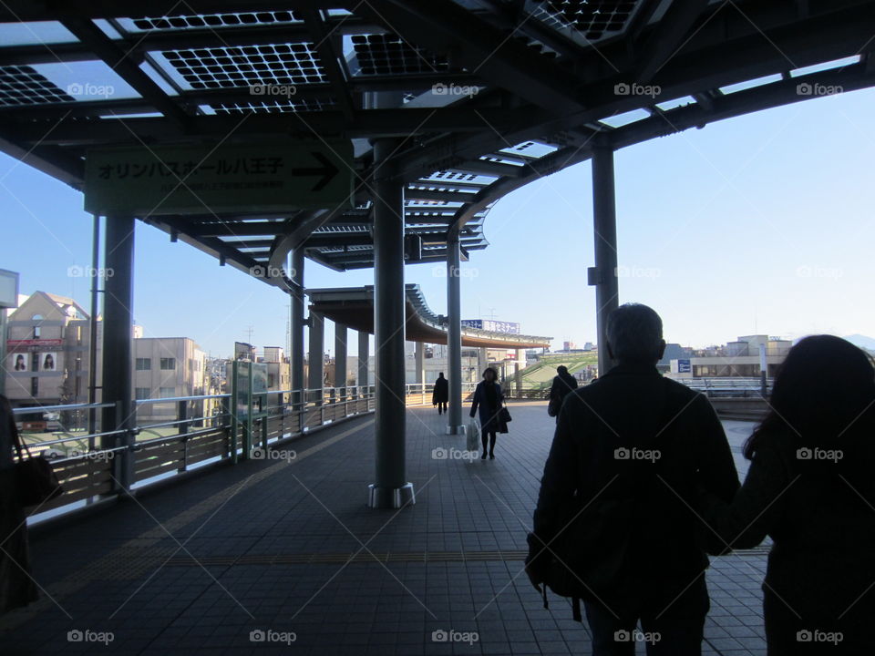 Older Couple Walking Hand in Hand, Hachiouji, Tokyo, Japan.  Southern Sky Tower. Silhouette.