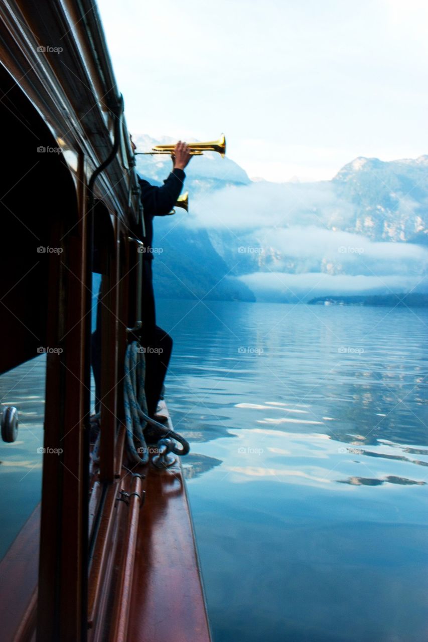 Man playing trumpet at sea