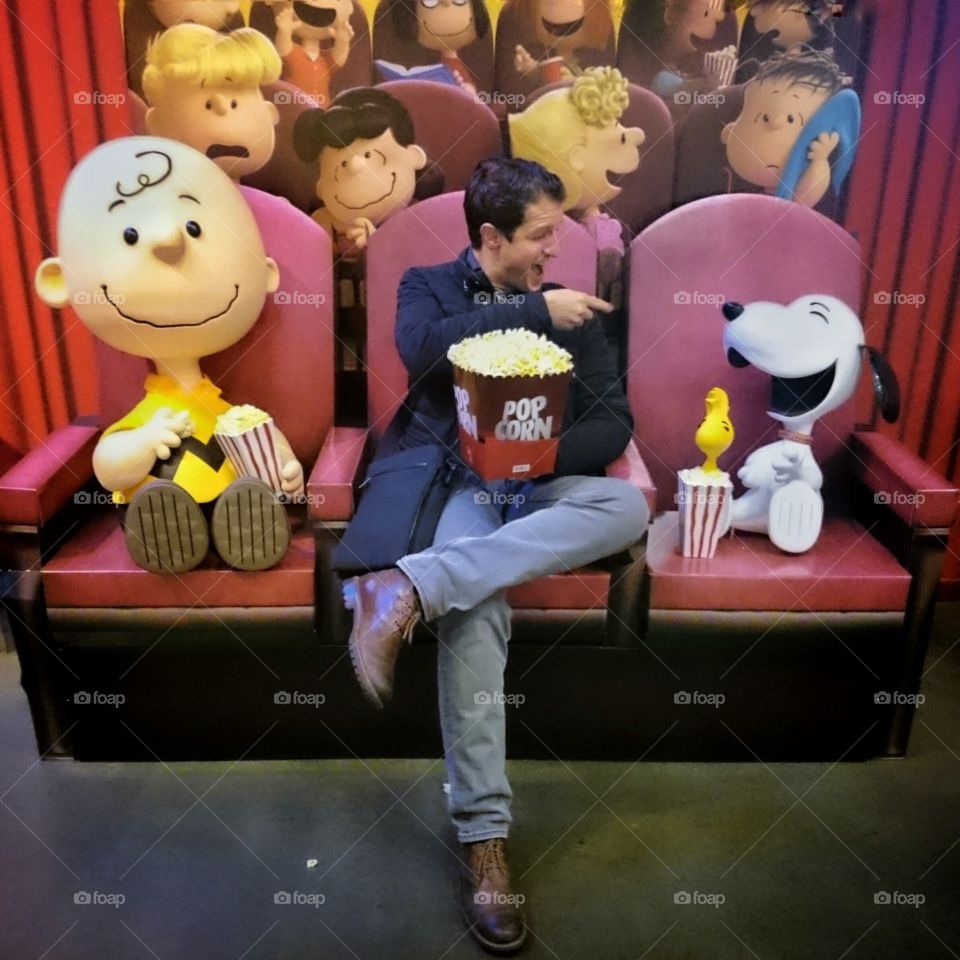 Man enjoying popcorn with toys in theater