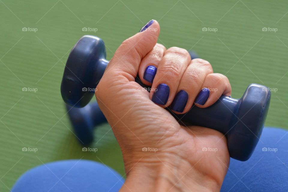 female hand with dumbbell, training  indoor