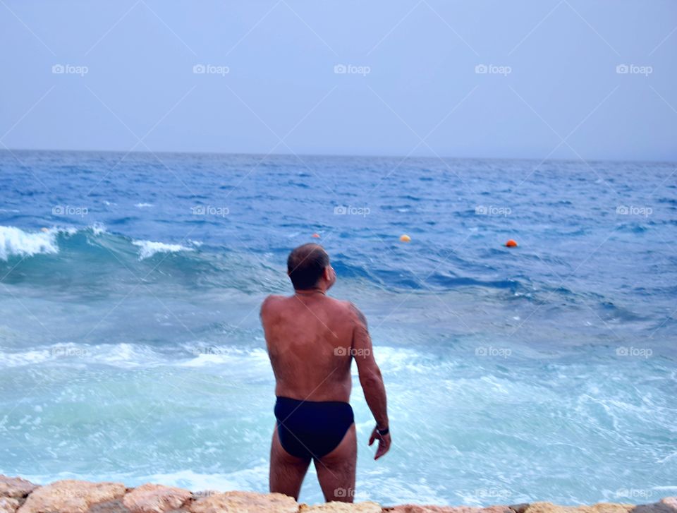 Sea spray. A man by the sea.