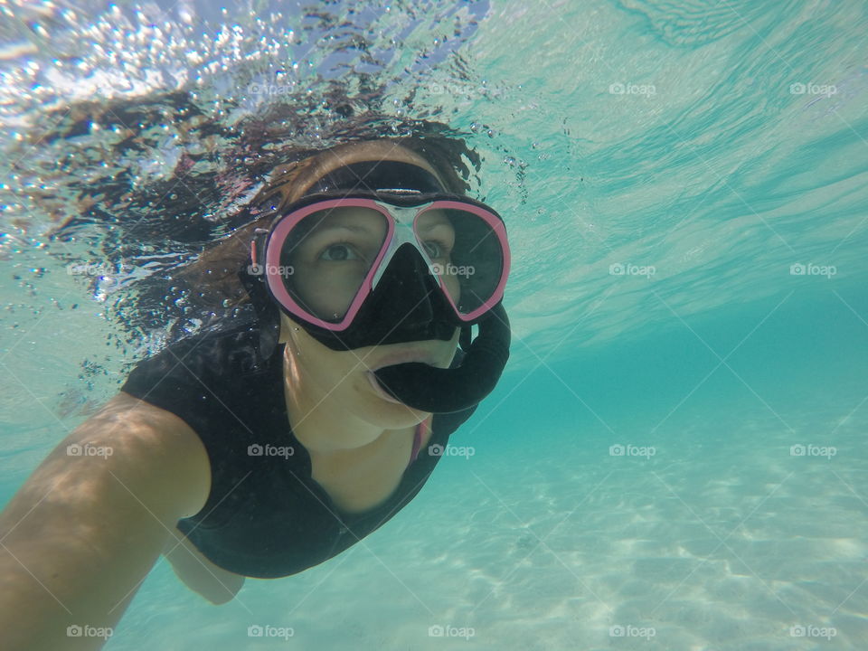 Woman snorkeling in clear water in the Bahamas