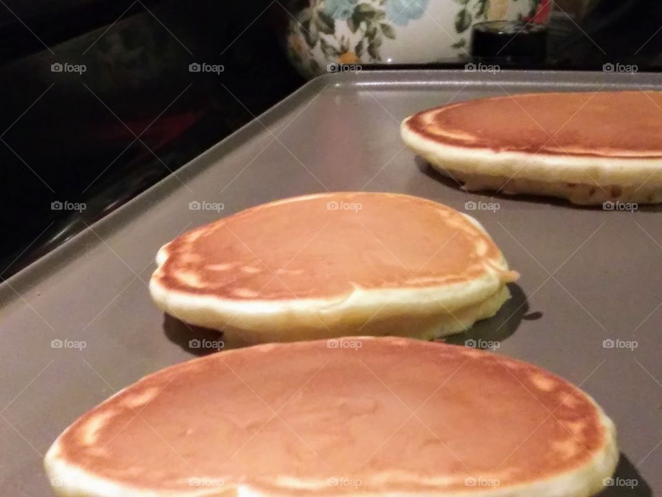 golden pancakes cooking on a griddle