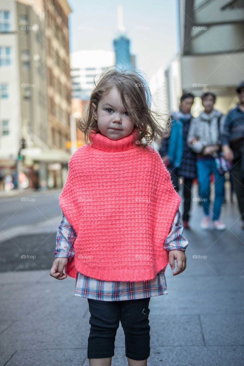 Cute girl standing on city street