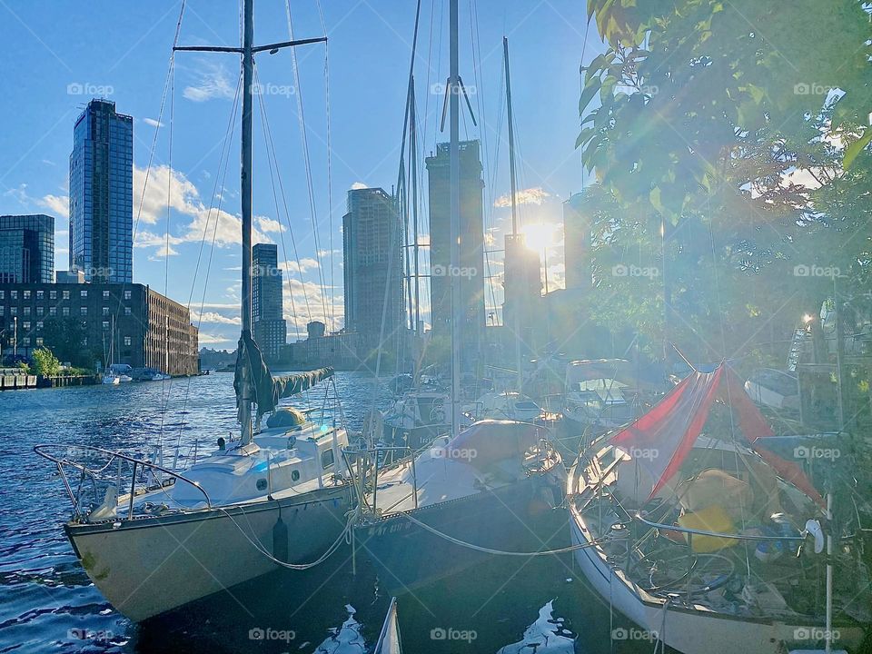 This is a lovely impression of “Newtown Creek” by the “Pulaski Bridge” in LIC, Queens with its many boats during sunset time. The setting sun bathes everything in its warm golden glow and causes a rainbow refraction effect. 2023. Hypnotic Productions