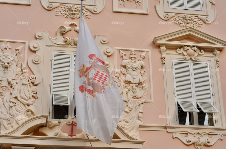 Decorative architectural elements of the royal palace in Monaco in pastel peach and yellow color scheme 