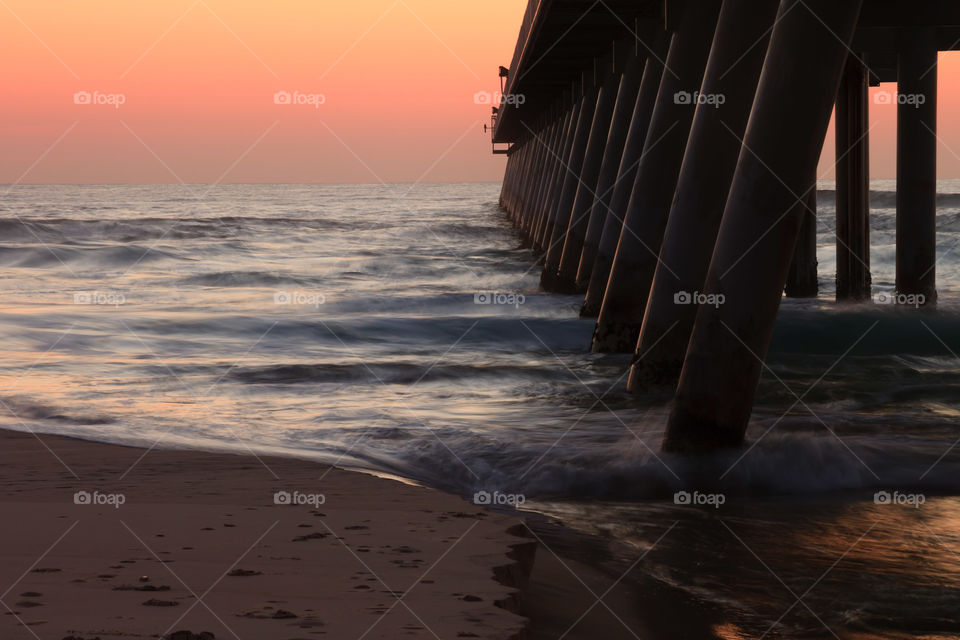 Pier columns at sea during sunset