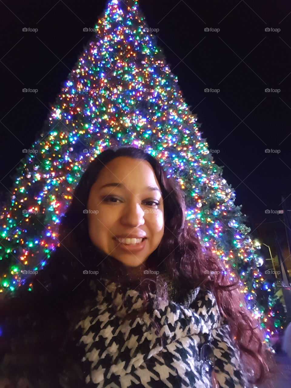 Close-up of a woman in front of decorated christmas tree