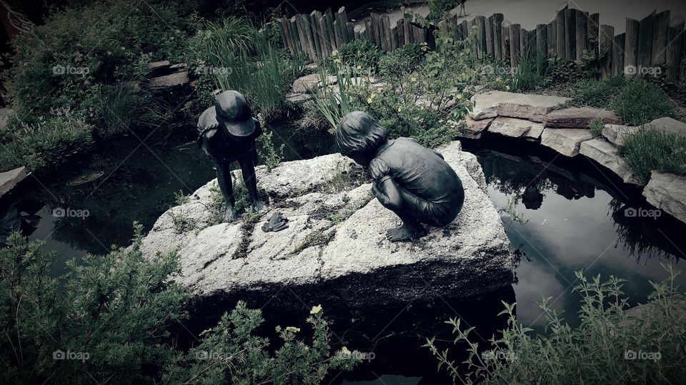 children playing with the Frog by a pond