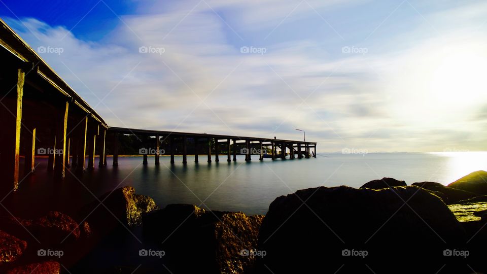 Wooden bridge at Rayong beach and beautiful sunlight with cloud 