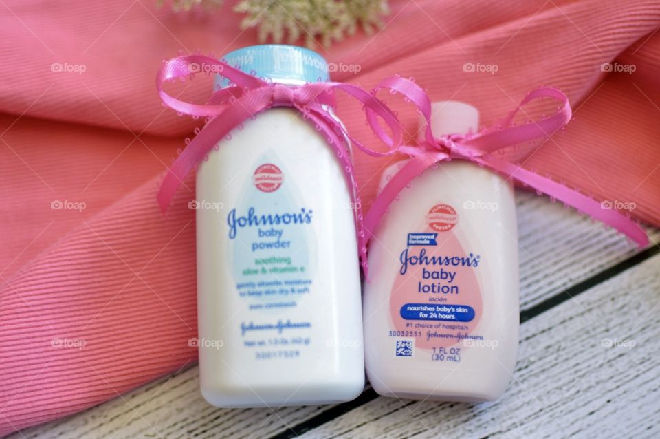 Johnson and Johnson baby lotion and powder with a pink ribbon and white background