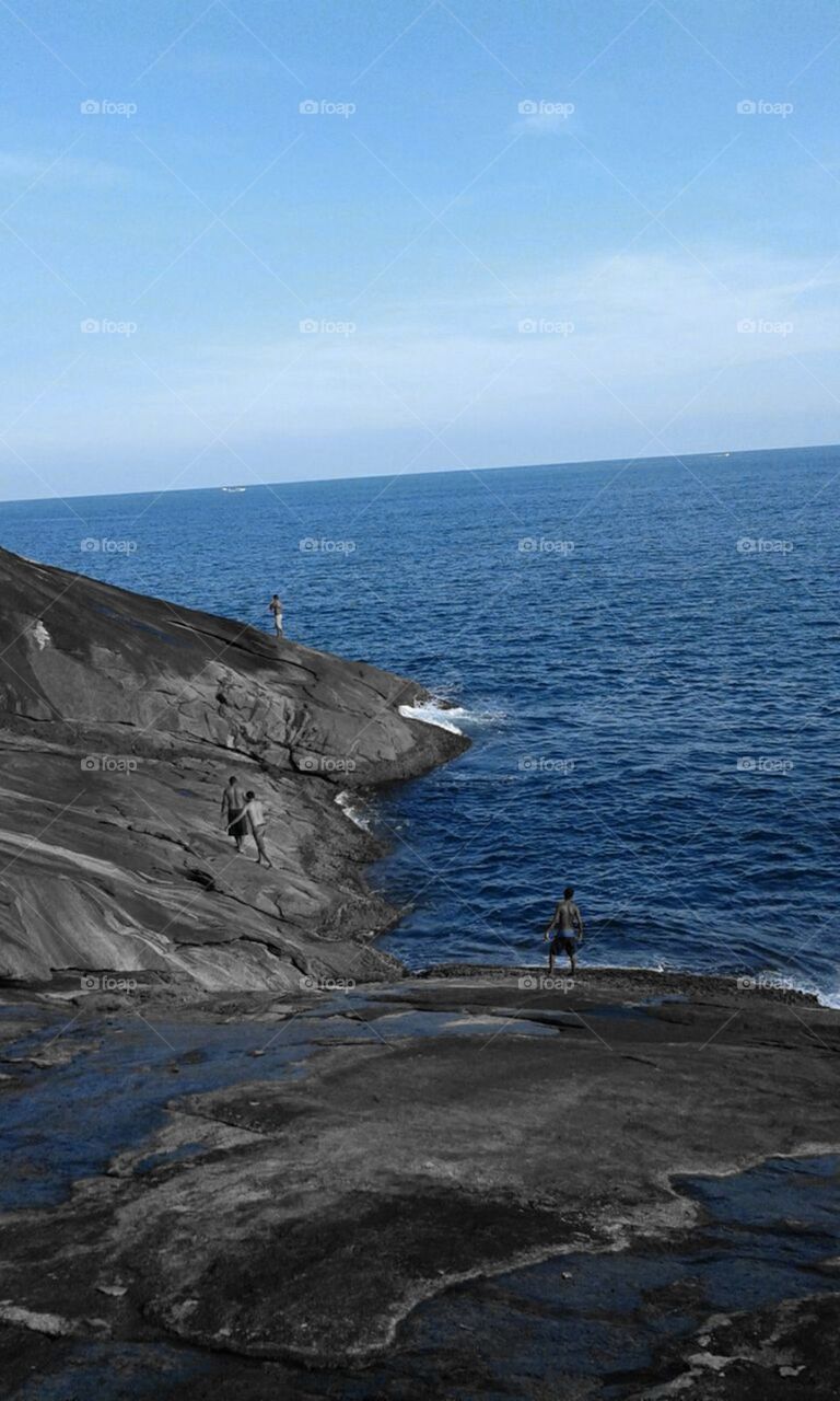 Imagem linda da rocha, das pessoas e do oceano.