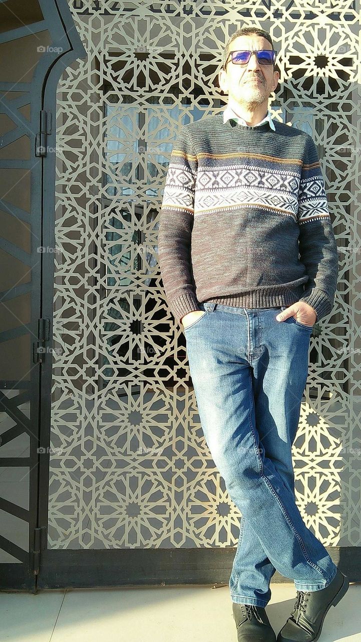 I m standing against mosaic Moroccan decoration.