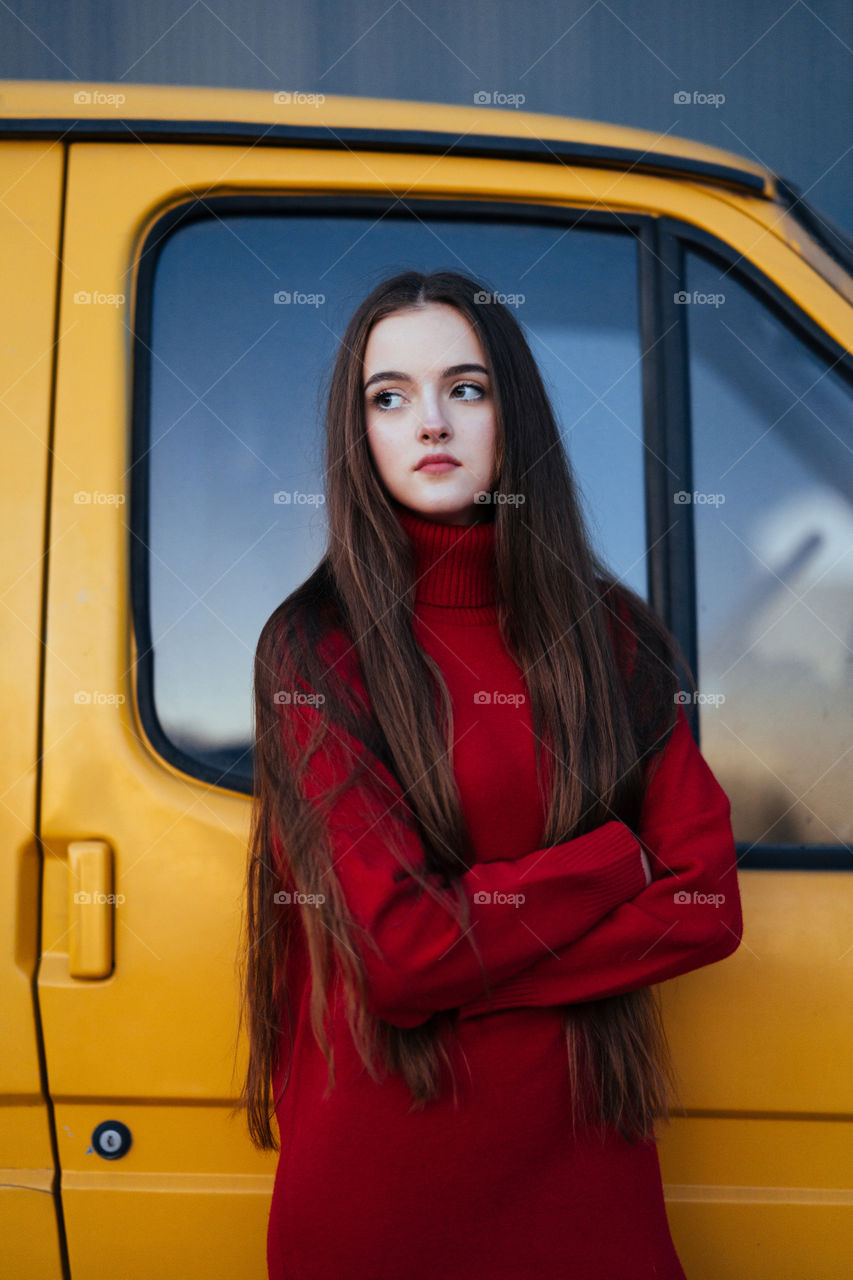 A young girl with long dark hair in red sweater. Close up portrait