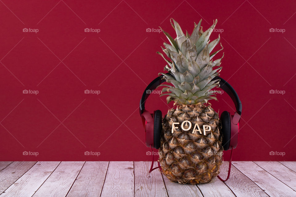 Foap written on pineapple with headphones. Foap is music, feeling and enjoyment!