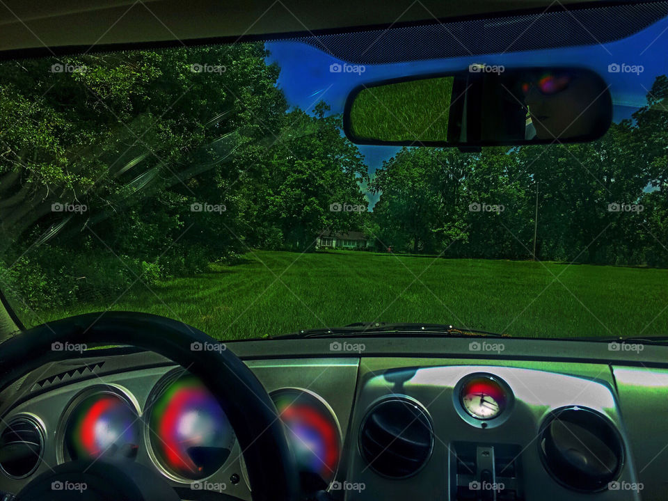 Grassy landscape seen through car's windscreen