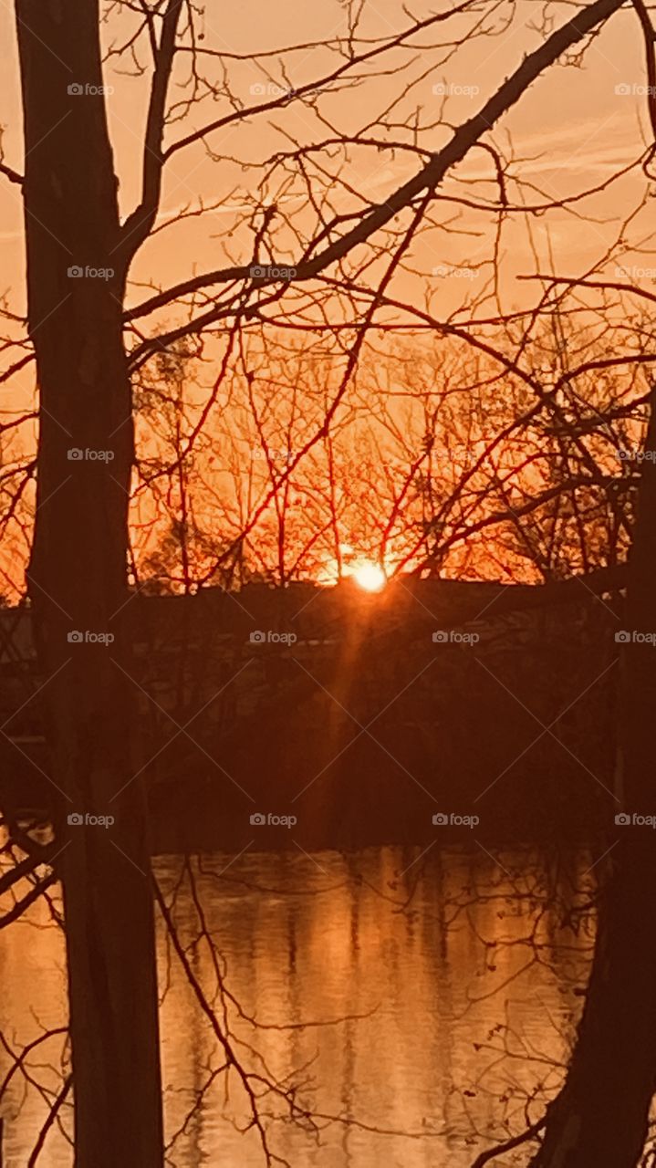 Evening Sunset high clouds spreading the sunbeams with the clouds. Evening colors appear strong for this early pic. Reflections of the Sunbeams / Rays off the lake waters.