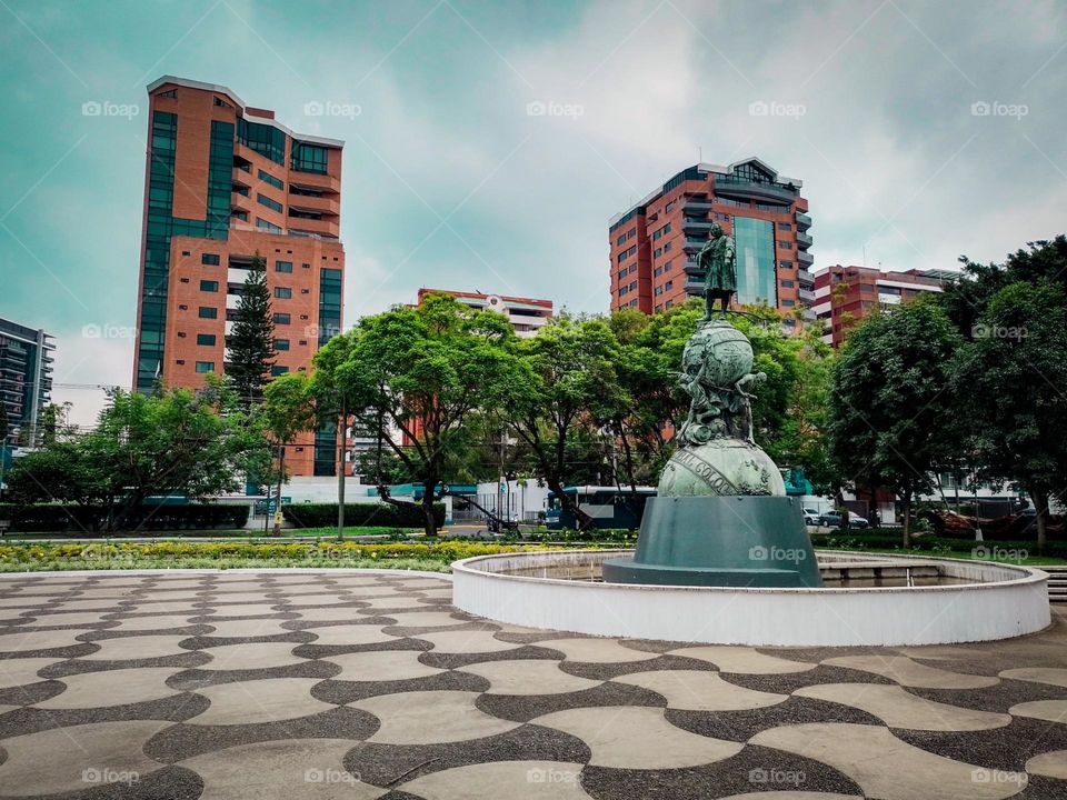 Monument to Christopher Columbus in Guatemala City, with a beautiful view of the buildings and trees that adorn it