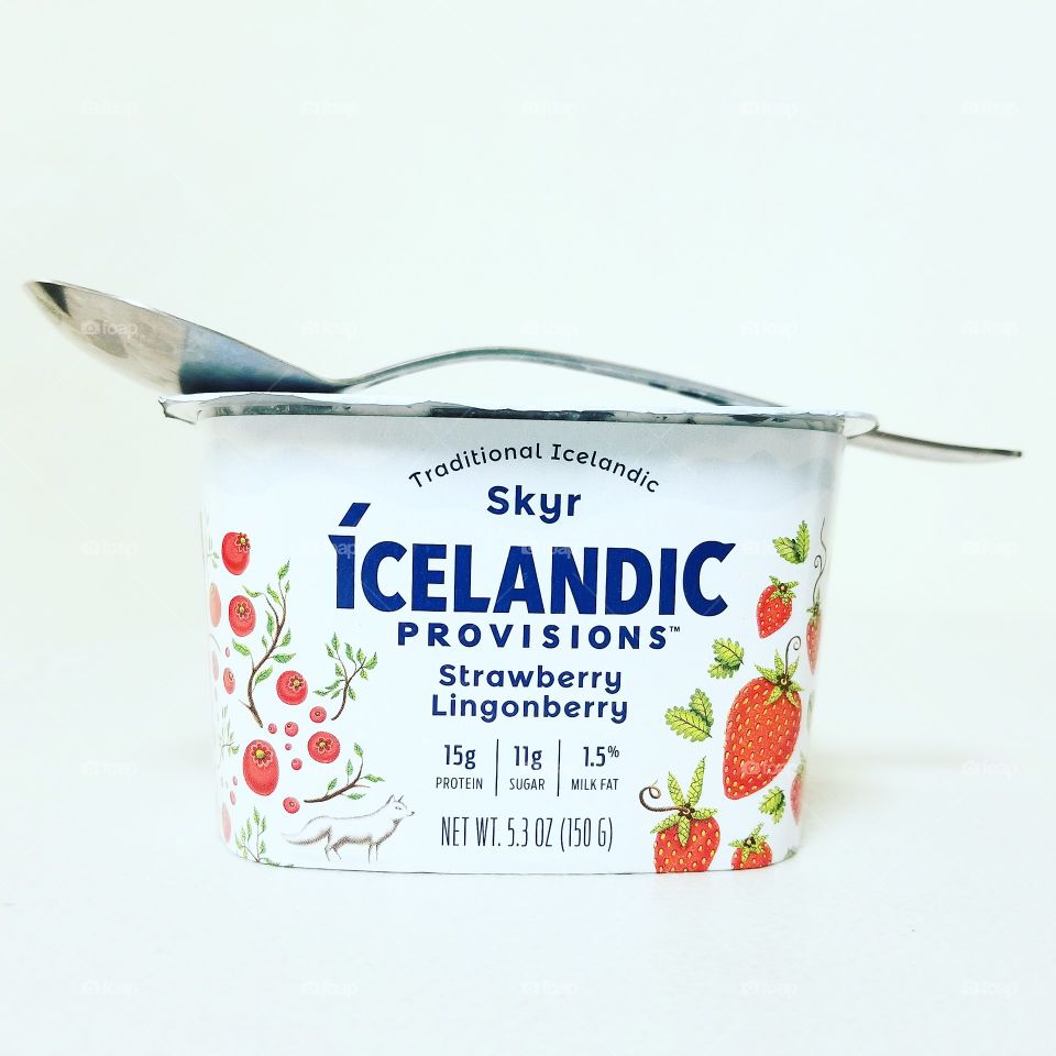Strawberry and lingonberry yogurt with a spoon