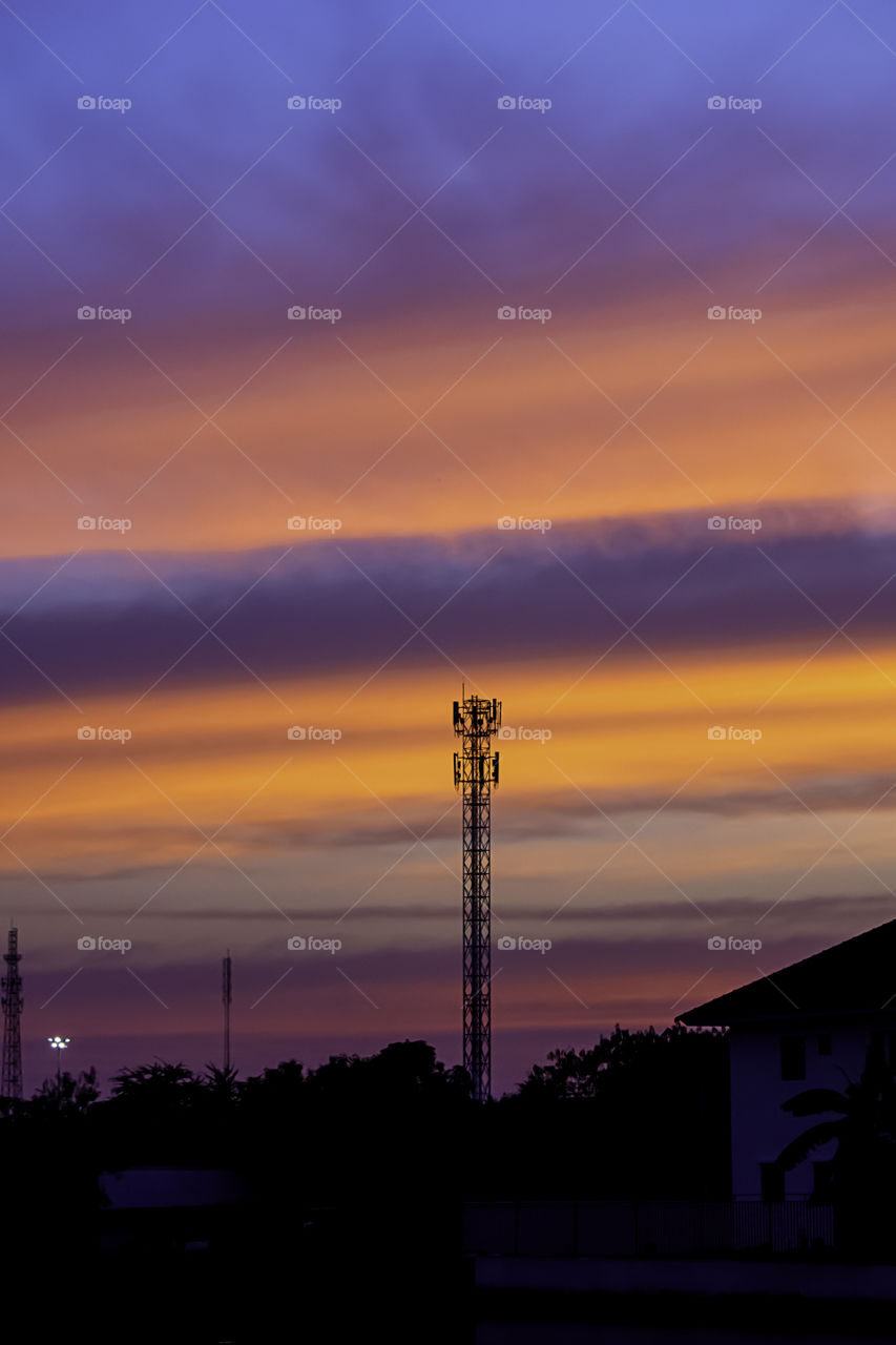 Beautiful light of sunset is orange after the telephone receiver antenna.