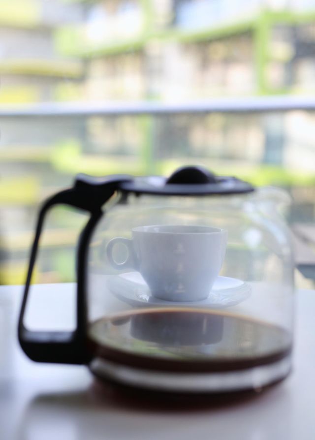 delicious coffee in a teapot and a white cup on the background, morning in the apartment