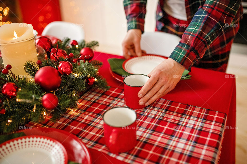 man sets a beautiful decorated winter table for a festive dinner.  Merry Christmas and Happy New Year.