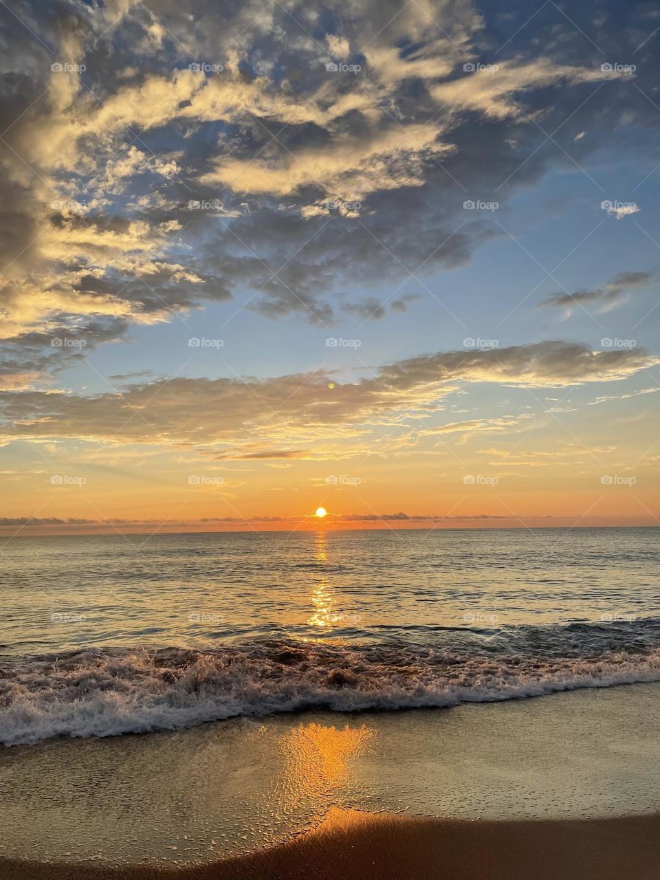 Beautiful sunrise beach scene with waves lapping on the shore in Florida