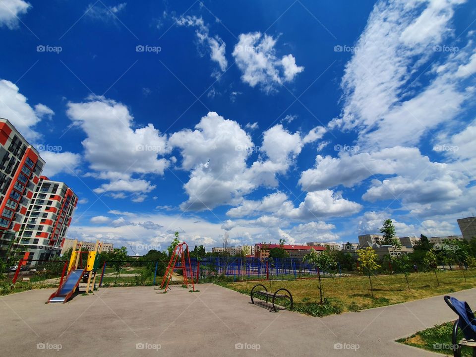 city view of cloudy sky, playground and stadium