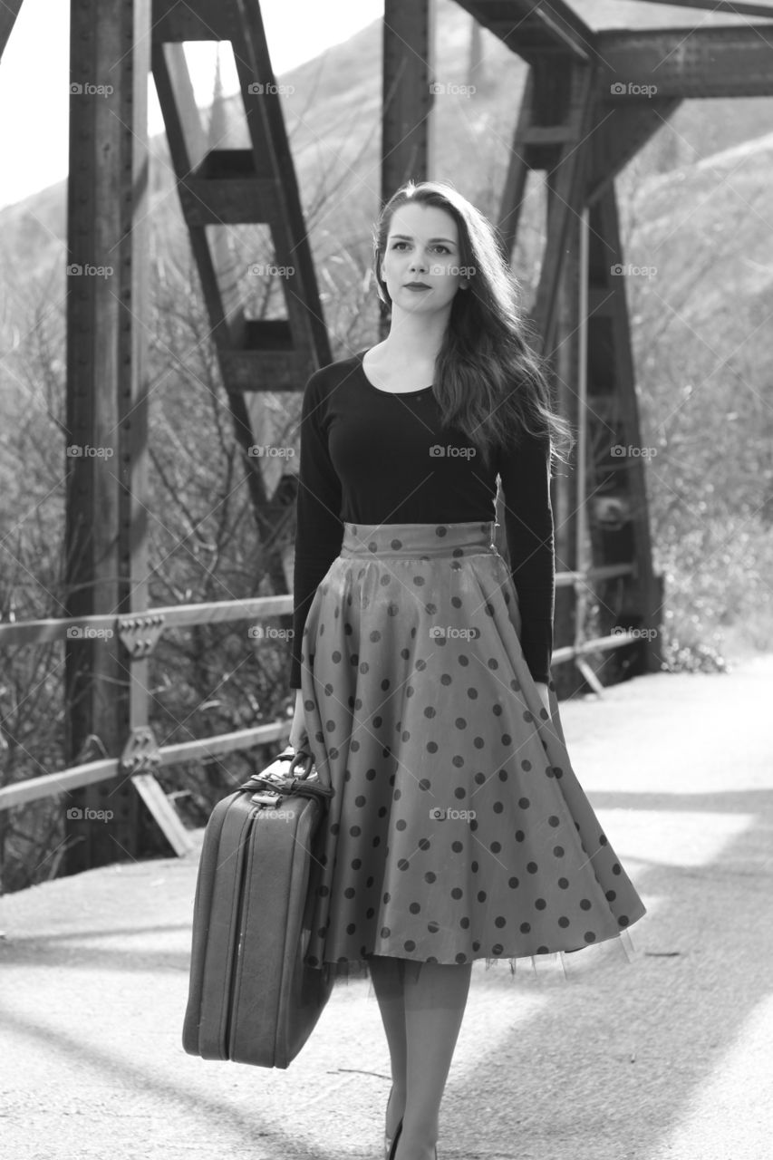 Portrait of pretty woman holding suitcase