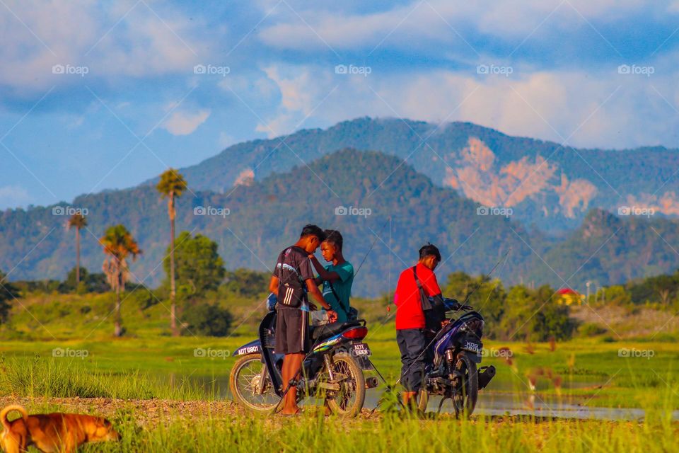People and motorcycles, parked the motorcycles beside a lake to go fishing