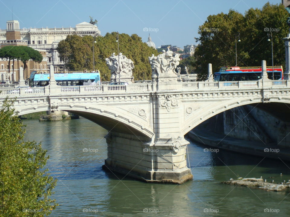 Stone bridge with statues over river in Rome, Italy
