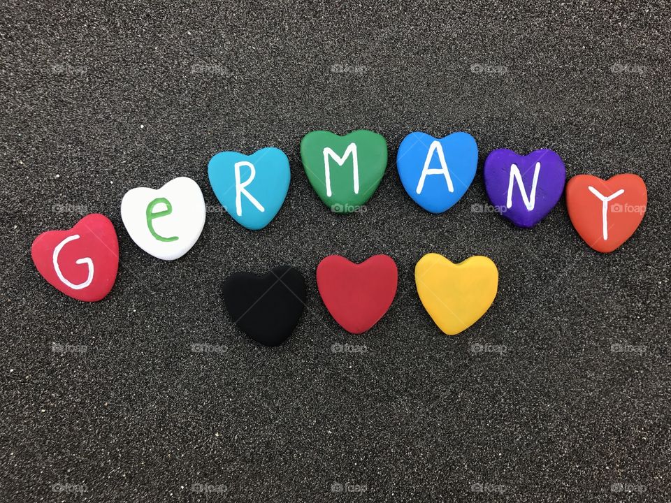 Germany with colored heart stones over black volcanic sand 